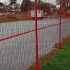 Red Canada temporary fence is set between the lawn and the road