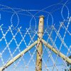 Welded razor mesh and flat wrap razor wire are installed on the wooden post